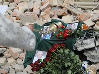 A priest is swinging the censer at the photographs of health professionals killed by the Russian missile attack on the Ohmatdyt National Spe...