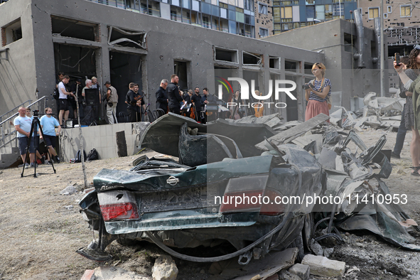 A crushed car is being pictured during the requiem for the victims of the Russian missile attack on the Ohmatdyt National Specialized Childr...