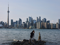 A woman is posing for a photo by the skyline of the city of Toronto seen from Centre Island in Toronto, Ontario, Canada, on July 13, 2024. (