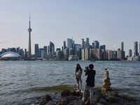 A woman is posing for a photo by the skyline of the city of Toronto seen from Centre Island in Toronto, Ontario, Canada, on July 13, 2024. (