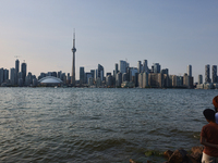 People are standing by the skyline of the city of Toronto, seen from Centre Island in Toronto, Ontario, Canada, on July 13, 2024. (