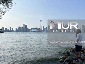 A Sikh man is looking out at the skyline of the city of Toronto seen from Centre Island in Toronto, Ontario, Canada, on July 13, 2024. (