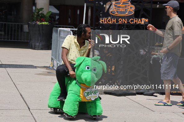 A man is riding on a motorized stuffed animal during the Taste of the Middle East Food Festival in Toronto, Ontario, Canada, on July 06, 202...