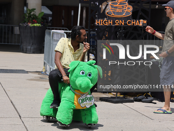 A man is riding on a motorized stuffed animal during the Taste of the Middle East Food Festival in Toronto, Ontario, Canada, on July 06, 202...