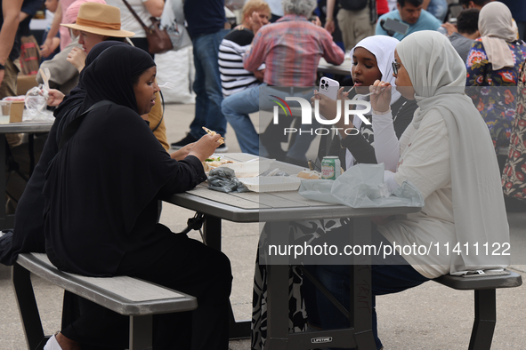 Women are enjoying various Middle Eastern foods during the Taste of the Middle East Food Festival in Toronto, Ontario, Canada, on July 06, 2...