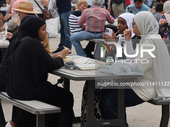 Women are enjoying various Middle Eastern foods during the Taste of the Middle East Food Festival in Toronto, Ontario, Canada, on July 06, 2...