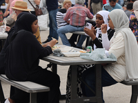 Women are enjoying various Middle Eastern foods during the Taste of the Middle East Food Festival in Toronto, Ontario, Canada, on July 06, 2...