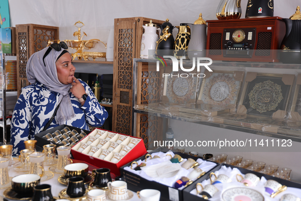 A woman is looking at various Islamic items from Dubai during the Taste of the Middle East Food Festival in Toronto, Ontario, Canada, on Jul...