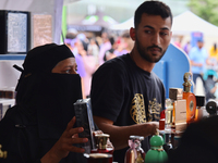 A woman is looking at perfume from Dubai during the Taste of the Middle East Food Festival in Toronto, Ontario, Canada, on July 06, 2024. Th...