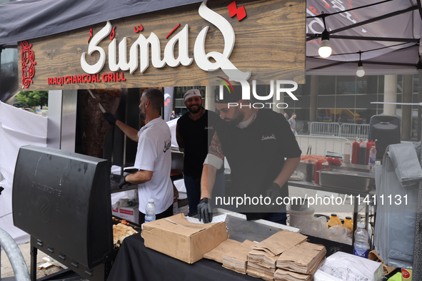 Men are preparing food at the Iraqi charcoal grill during the Taste of the Middle East Food Festival in Toronto, Ontario, Canada, on July 06...