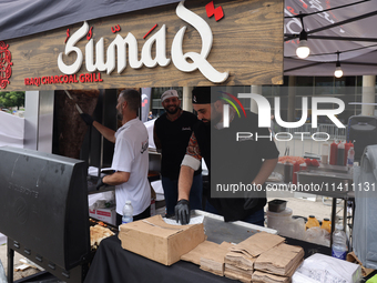 Men are preparing food at the Iraqi charcoal grill during the Taste of the Middle East Food Festival in Toronto, Ontario, Canada, on July 06...