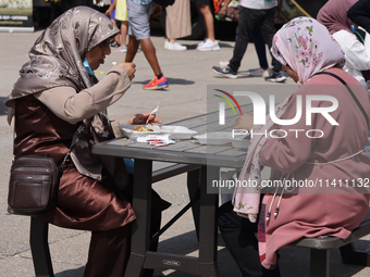 Women are enjoying various Middle Eastern foods during the Taste of the Middle East Food Festival in Toronto, Ontario, Canada, on July 06, 2...