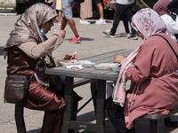 Women are enjoying various Middle Eastern foods during the Taste of the Middle East Food Festival in Toronto, Ontario, Canada, on July 06, 2...