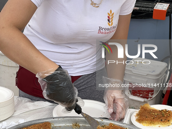 A woman is serving Kunafa in Toronto, Ontario, Canada, on June 06, 2024. Kunafa (knafeh) is a traditional Arabic dessert, made with spun pas...