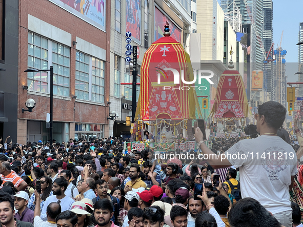 Thousands of Hindu devotees are taking part in the chariot procession as they escort the chariots carrying the deities during the annual Rat...