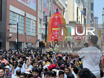 Thousands of Hindu devotees are taking part in the chariot procession as they escort the chariots carrying the deities during the annual Rat...