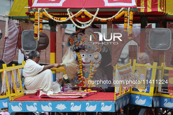 Hindu priests are performing prayers while traveling in the chariots carrying the deities during the annual Rath Yatra festival in Toronto,...