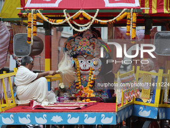 Hindu priests are performing prayers while traveling in the chariots carrying the deities during the annual Rath Yatra festival in Toronto,...