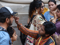 Tikkas are being applied to the foreheads of devotees as thousands of Hindu devotees are taking part in the procession during the annual Rat...