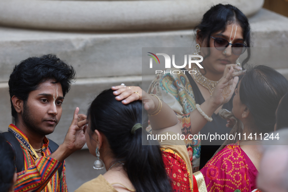 Tikkas are being applied to the foreheads of devotees as thousands of Hindu devotees are taking part in the procession during the annual Rat...