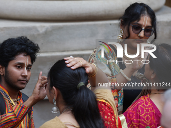 Tikkas are being applied to the foreheads of devotees as thousands of Hindu devotees are taking part in the procession during the annual Rat...