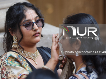 Tikkas are being applied to the foreheads of devotees as thousands of Hindu devotees are taking part in the procession during the annual Rat...