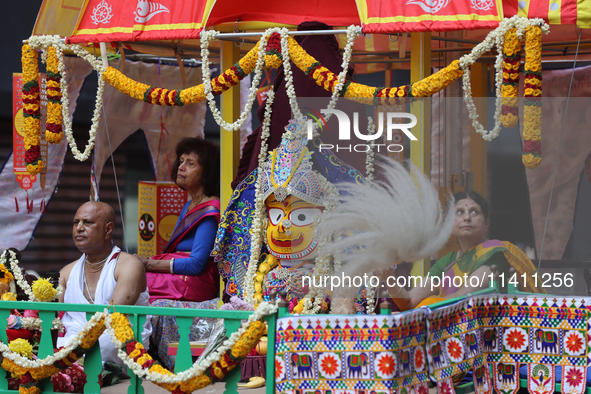 Hindu priests are performing prayers while traveling in the chariots carrying the deities during the annual Rath Yatra festival in Toronto,...