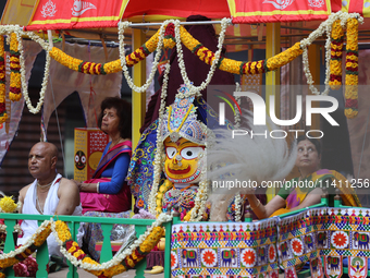 Hindu priests are performing prayers while traveling in the chariots carrying the deities during the annual Rath Yatra festival in Toronto,...