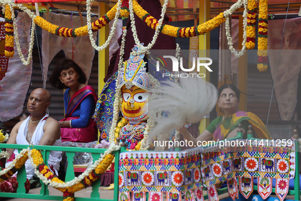 Hindu priests are performing prayers while traveling in the chariots carrying the deities during the annual Rath Yatra festival in Toronto,...