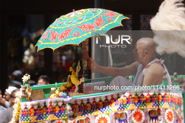 A Hindu priest is traveling in a chariot carrying the deities during the annual Rath Yatra festival in Toronto, Ontario, Canada, on July 13,...