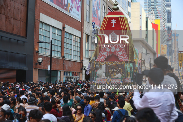 Thousands of Hindu devotees are taking part in the chariot procession as they escort the chariots carrying the deities during the annual Rat...