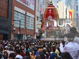 Thousands of Hindu devotees are taking part in the chariot procession as they escort the chariots carrying the deities during the annual Rat...