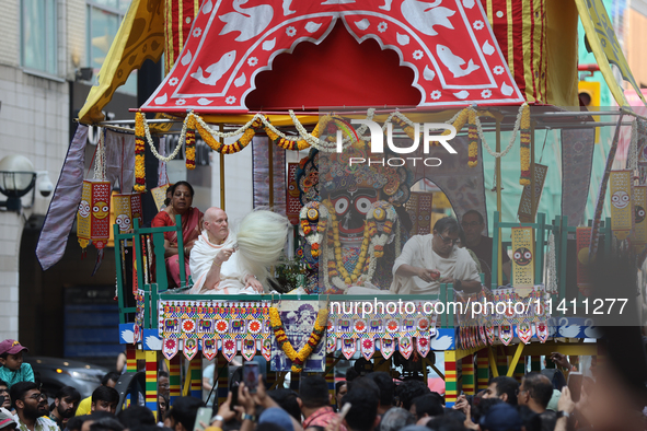 Hindu priests are performing prayers while traveling in the chariots carrying the deities during the annual Rath Yatra festival in Toronto,...