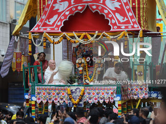 Hindu priests are performing prayers while traveling in the chariots carrying the deities during the annual Rath Yatra festival in Toronto,...