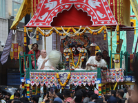 Hindu priests are performing prayers while traveling in the chariots carrying the deities during the annual Rath Yatra festival in Toronto,...