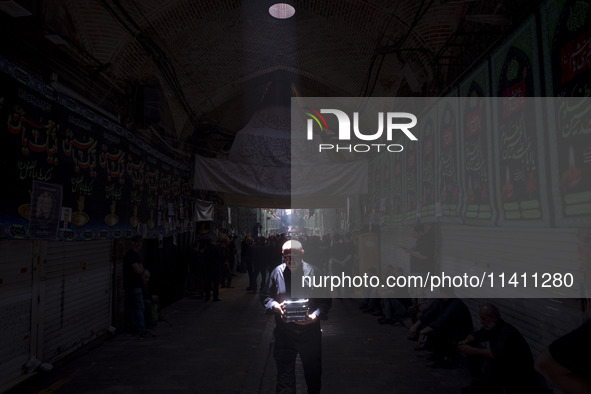 An elderly Iranian man is carrying packs of donated meals after participating in a religious festival to commemorate Tasoua, a day ahead of...