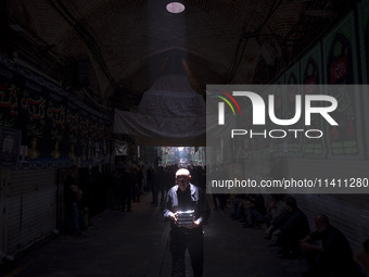 An elderly Iranian man is carrying packs of donated meals after participating in a religious festival to commemorate Tasoua, a day ahead of...