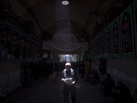 An elderly Iranian man is carrying packs of donated meals after participating in a religious festival to commemorate Tasoua, a day ahead of...