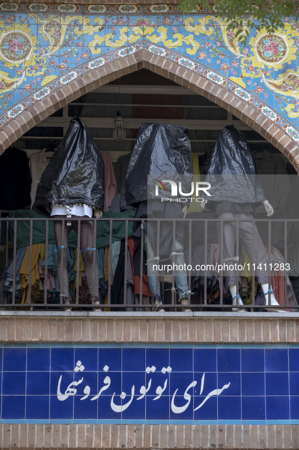 Mannequins are being covered with black plastic bags during a religious festival to commemorate Tasoua, a day ahead of Ashura, at a shop in...