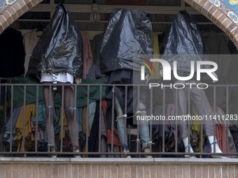 Mannequins are being covered with black plastic bags during a religious festival to commemorate Tasoua, a day ahead of Ashura, at a shop in...