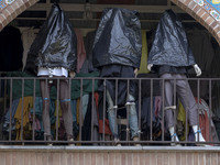 Mannequins are being covered with black plastic bags during a religious festival to commemorate Tasoua, a day ahead of Ashura, at a shop in...