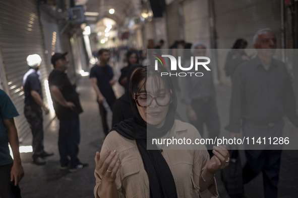 A young Iranian woman is praying while participating in a religious festival to commemorate Tasoua, a day ahead of Ashura, in the Grand Baza...