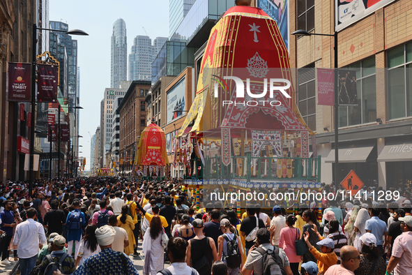 Thousands of Hindu devotees are taking part in the chariot procession as they escort the chariots carrying the deities during the annual Rat...