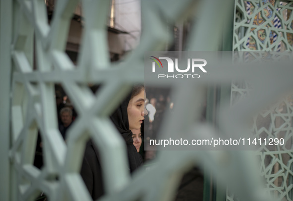 A young Iranian woman is walking into a mosque during a religious festival to commemorate Tasoua, a day ahead of Ashura, in the Grand Bazaar...