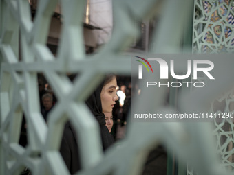 A young Iranian woman is walking into a mosque during a religious festival to commemorate Tasoua, a day ahead of Ashura, in the Grand Bazaar...