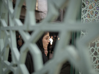 A young Iranian woman is walking into a mosque during a religious festival to commemorate Tasoua, a day ahead of Ashura, in the Grand Bazaar...