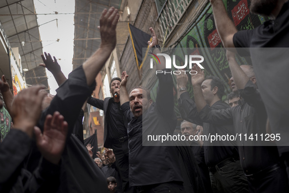 Iranian mourners are beating themselves while participating in a religious festival to commemorate Tasoua, a day ahead of Ashura, in the Gra...