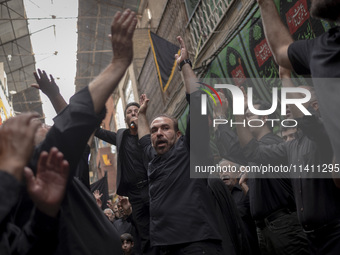 Iranian mourners are beating themselves while participating in a religious festival to commemorate Tasoua, a day ahead of Ashura, in the Gra...