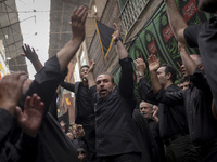 Iranian mourners are beating themselves while participating in a religious festival to commemorate Tasoua, a day ahead of Ashura, in the Gra...