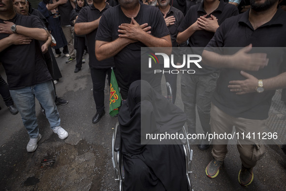 Iranian mourners are beating themselves during a religious festival to commemorate Tasoua, a day ahead of Ashura, while an elderly veiled wo...